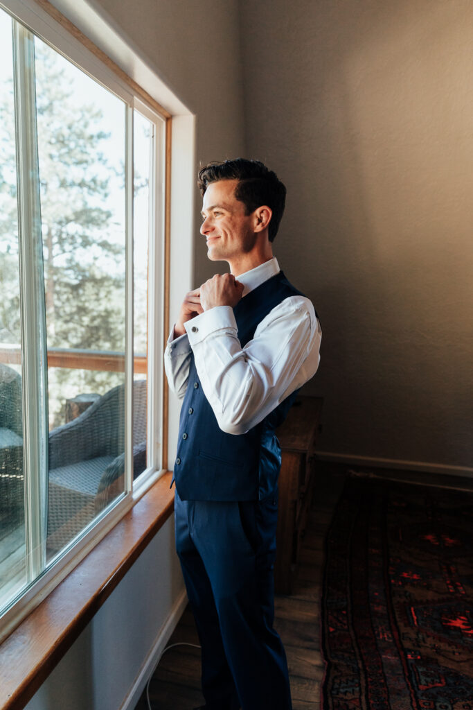 Groom getting ready at an Airbnb elopement in Bailey, Colorado