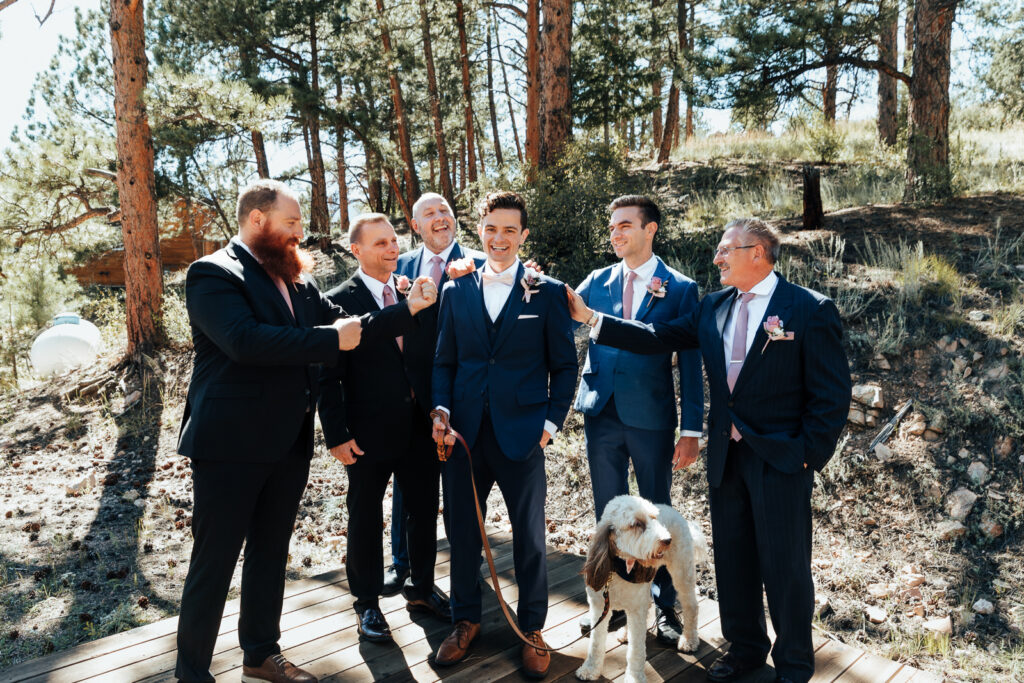 The groom laughing with the guys at an Airbnb elopement in Bailey, Colorado