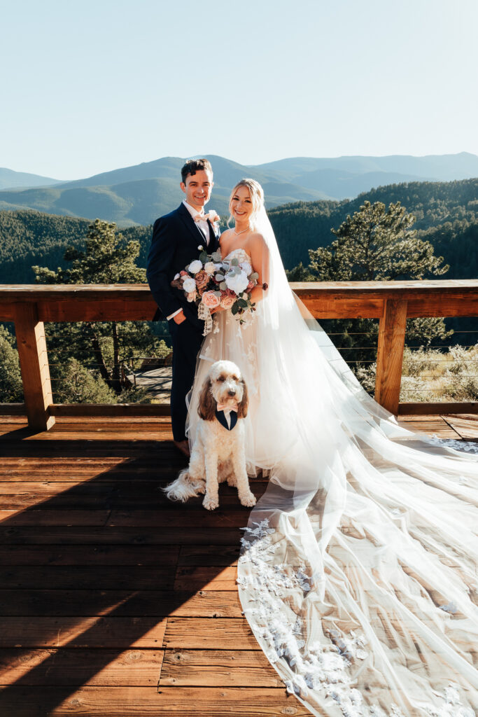 A couple smiling with their dog at their Airbnb elopement in Bailey, Colorado