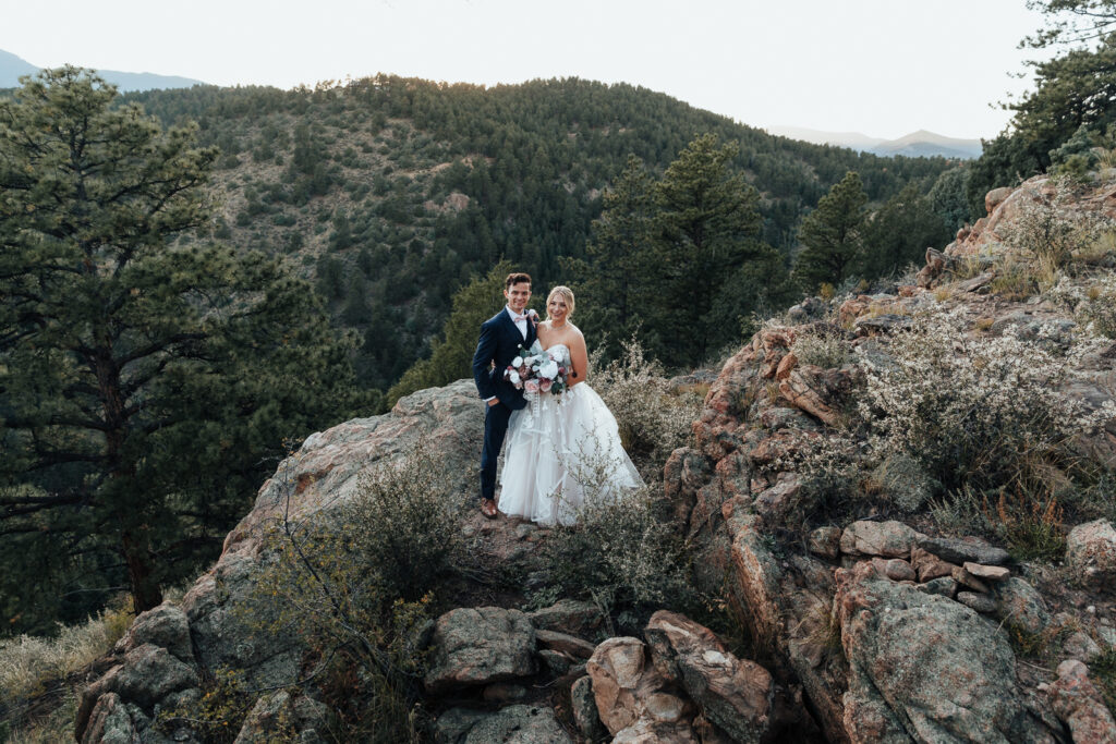 A couple smiling enjoying the landscape at their Airbnb elopement in Bailey, Colorado