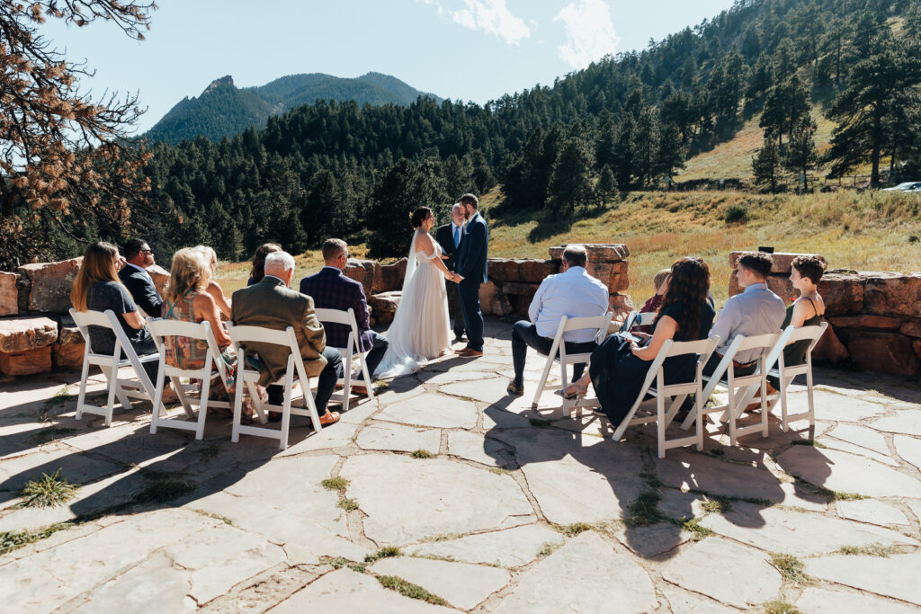 Couple exchanging vows in front of their family at their elopement at the Halfway House near Denver