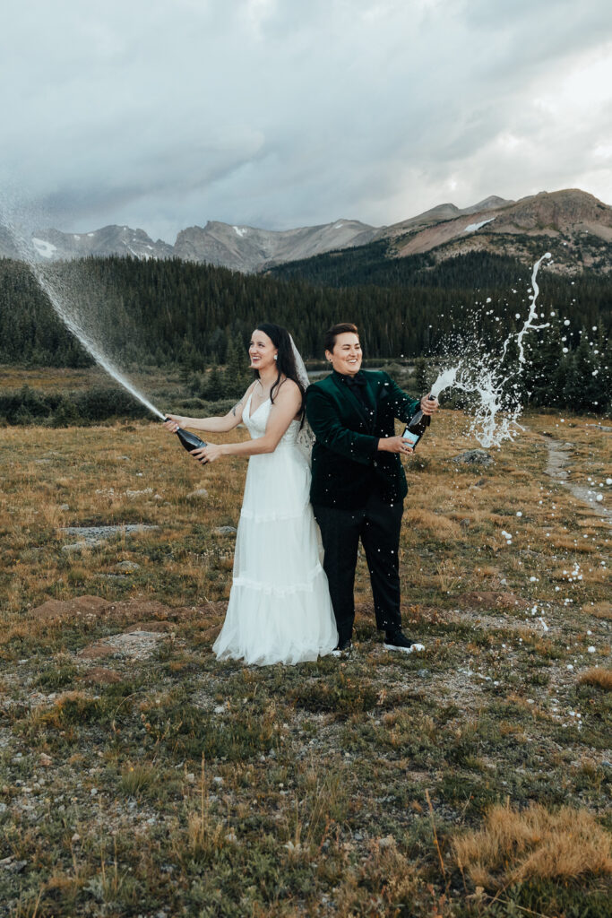A couple spraying champagne at Brainard Lake, Colorado