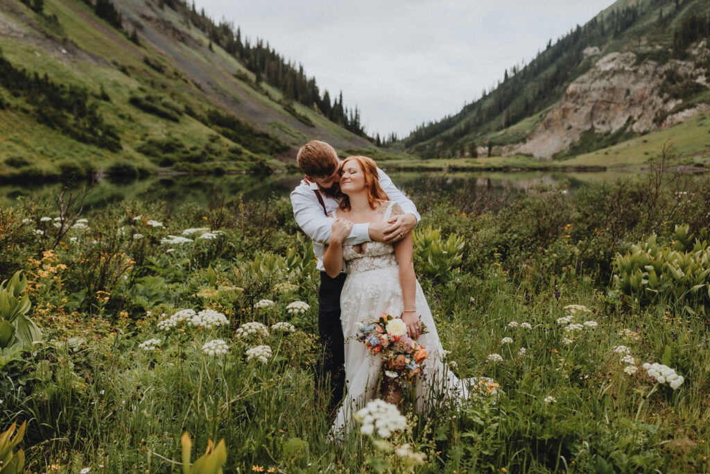 Couple hugging in a field of flowers in Crested Butte, Colorado