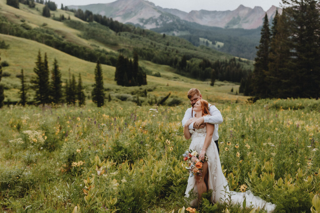 A couple hugging in a field of flowers in Crested Butte, Colorado