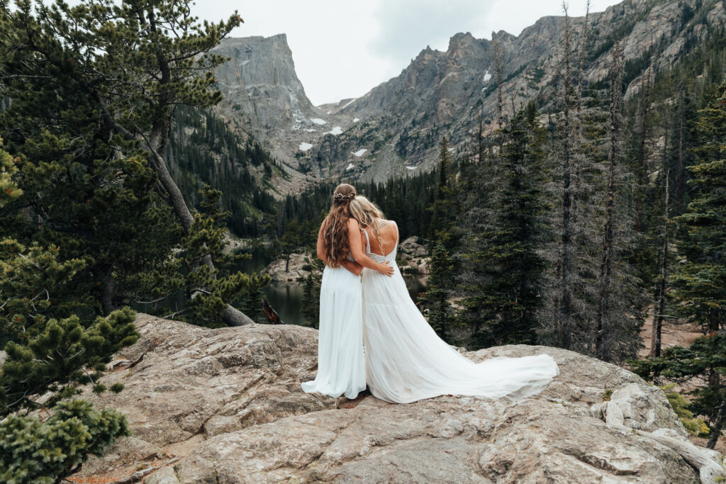 Couple standing and admiring the mountains at Dream Lake, Rocky Mountain National Park.