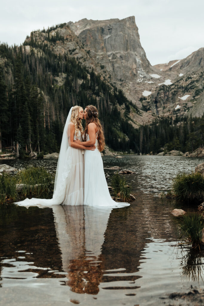 A couple kissing while standing in Dream Lake, Rocky Mountain National Park in Estes Park