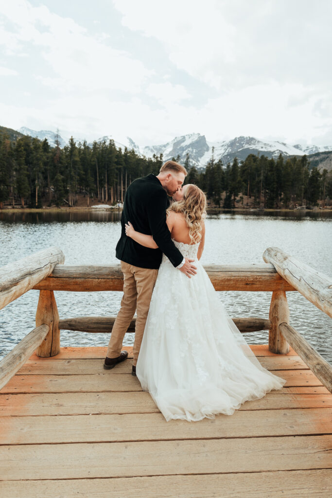 Couple kissing on the dock at Sprague Lake in Rocky Mountain National Park 