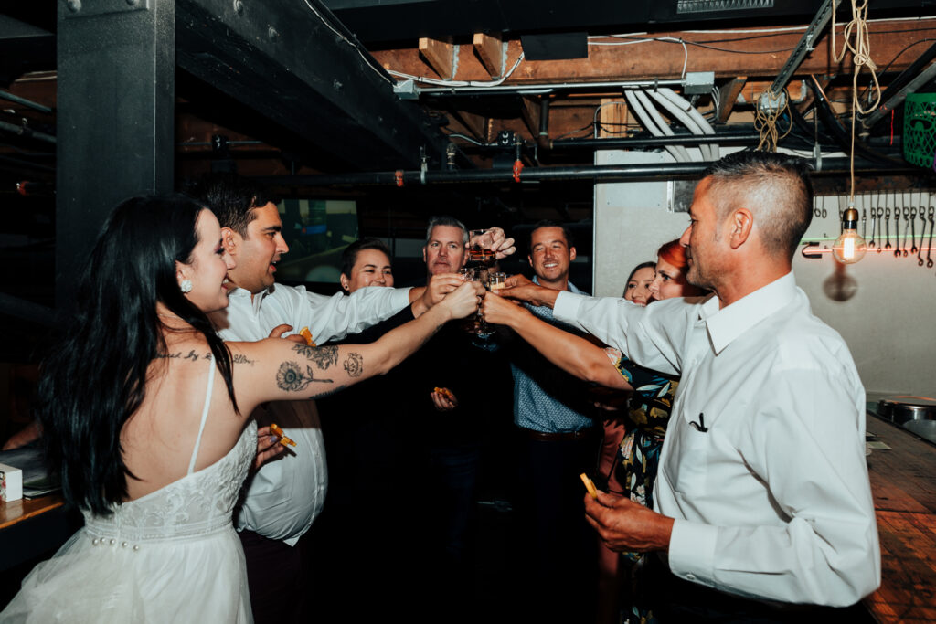 A couple and their family sharing celebratory shots at their elopement reception in Boulder, Colorado 